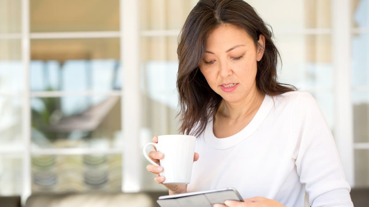 A tablet and a cup of coffee on a table, a quiet moment of reading.